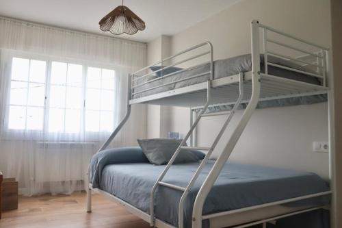 a bedroom with two bunk beds with a blue bed at Apartamento Jañota en la Costa da Morte in Buño