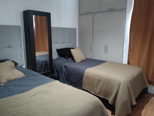 a bedroom with two beds and a mirror at Cozy accommodation 3 min Distrito Uno in Chihuahua