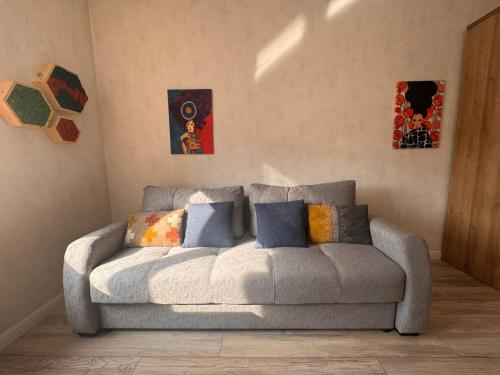 a couch in a living room with paintings on the wall at Altin Residens in Karagandy