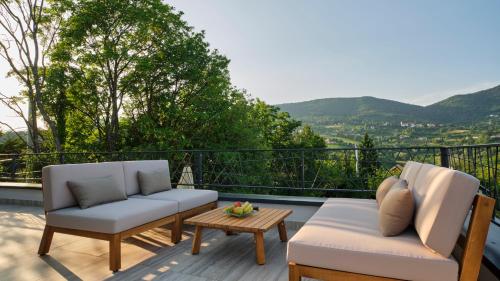 a patio with two chairs and a table on a balcony at Villa Terra in Plešivica