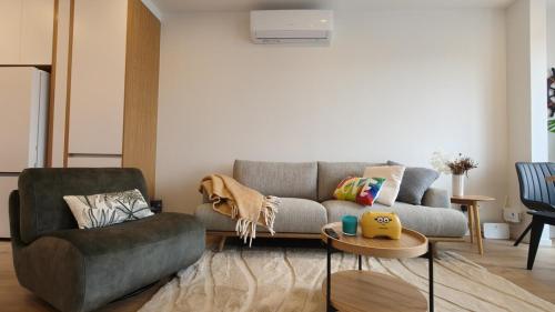 a living room with a couch and a chair at Brand New Spacious 5BR Home in Central AKL in Auckland