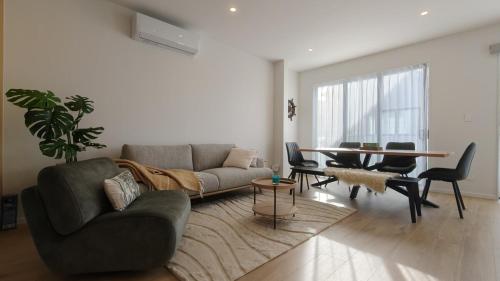 a living room with a couch and a table at Brand New Spacious 5BR Home in Central AKL in Auckland