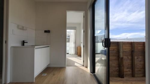a kitchen with a view of the ocean through a glass door at Brand New Spacious 5BR Home in Central AKL in Auckland