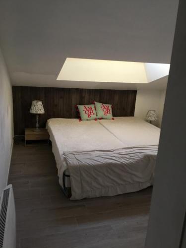 a bedroom with a bed with two pillows on it at Le 7ter, maison calme piscine partagée in Saint-Laurent-sur-Sèvre