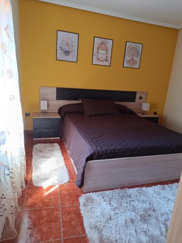 a bedroom with a bed and a yellow wall at Sol River in Guardo