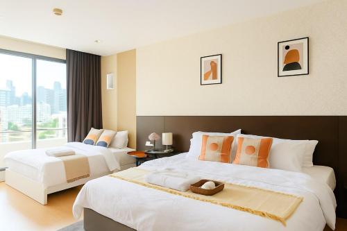 une chambre d'hôtel avec deux lits et une grande fenêtre dans l'établissement Modern 2 Bed Executive Unit - 5min to Nana BTS, à Bangkok