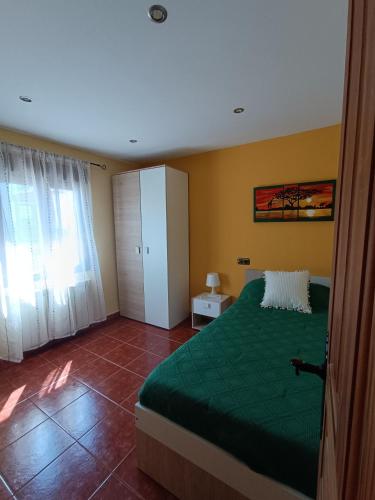 a bedroom with a green bed and yellow walls at Sol River in Guardo