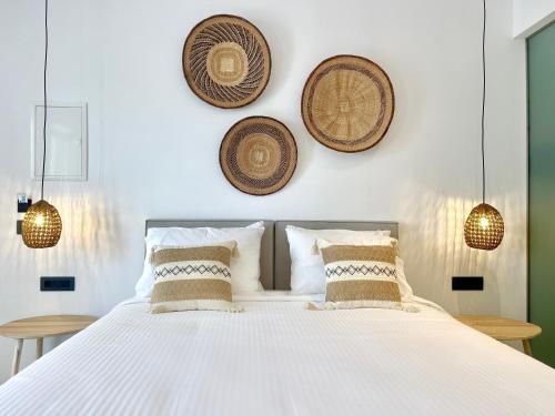a bedroom with a white bed with baskets on the wall at Mykonos Dot Suites in Ano Mera
