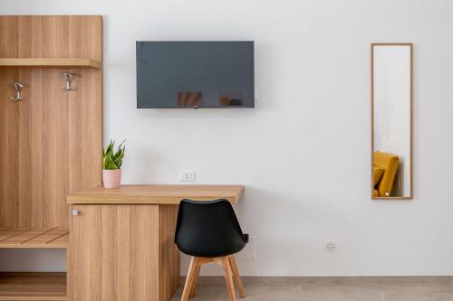 a desk with a chair and a television on a wall at Casa Agata in Leverano