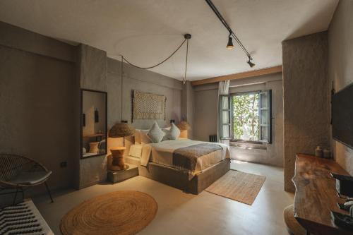 a bedroom with a bed and a chair and a window at GAIA ALAÇATI in Alaçatı