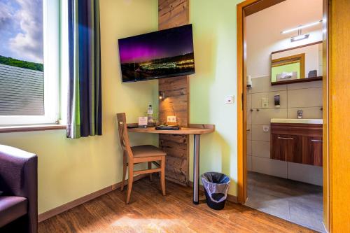 a small desk in a room with a sink and a tv at Altes Schulhaus in Zeltingen-Rachtig