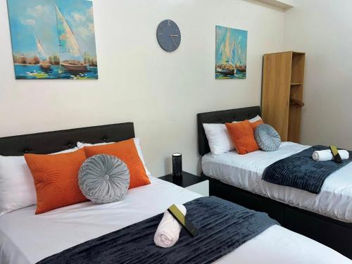 a room with two beds and a clock on the wall at Elim Escape Staycation in Trece Martires