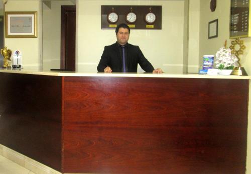 a man sitting at a counter in a salon at Al Sharq Hotel in Sharjah