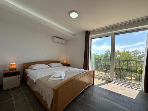 a bedroom with a bed and a large window at Gazdinstvo Đurović in Dobra Voda