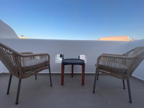two chairs and a table with a blue light at Theofanis Studios in Agia Anna Naxos