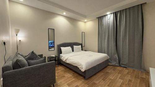 ジッダにあるشقة انيقة استديو بدخول ذاتيのベッドと椅子とソファのある寝室