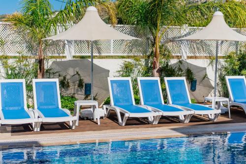a group of blue and white chairs next to a swimming pool at Via Farilya Hotel in Gundogan