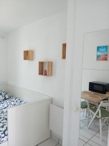 une petite pièce avec un lit et une table dans l'établissement Appartement cosy proche plage, à Saint-Nazaire