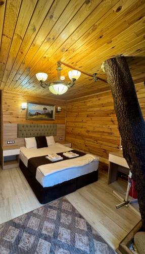 a bedroom with a bed in a wooden room at Ensar Apart in Uzungöl