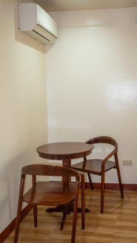 two tables and a chair in a room at Tessie's Home Stay Bed & Breakfast in Puerto Princesa City