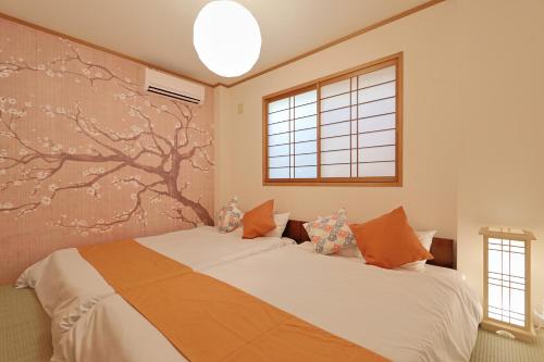 a bedroom with a bed and a tree mural at Spacious Family Home Sleeps 13 Near USJ & Osaka Station in Osaka