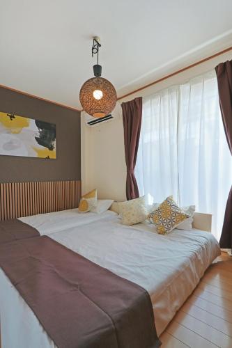 a bedroom with a large white bed with curtains at Spacious Family Home Sleeps 13 Near USJ & Osaka Station in Osaka
