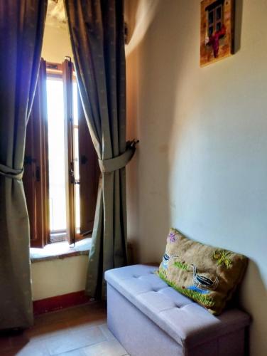 a room with a window with a couch and a pillow at Castellare in Chiusdino
