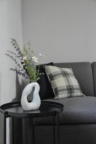 a vase on a table next to a couch at Viktor Estate in Deskle