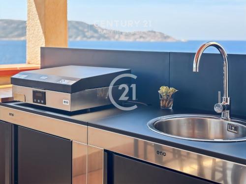 une cuisine avec un évier et un comptoir. dans l'établissement Pointe St-François T3 vue mer, à Calvi