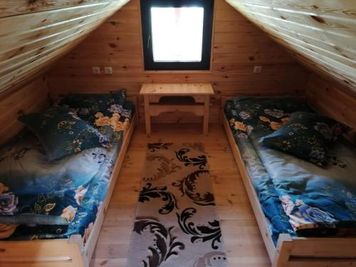 2 Betten im Dachgeschoss eines Blockhauses in der Unterkunft Pensiunea Mars House in Ciocăneşti