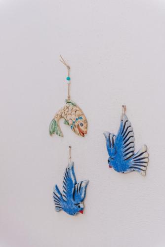 four blue birds hanging on a wall at Via Farilya Hotel in Gundogan