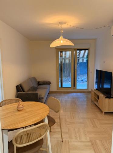 un salon avec une table et un canapé dans l'établissement New 2-Room Apartement AC & Private Garden, à Nice