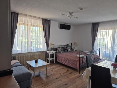 a bedroom with a bed and a living room at Apartment Rosalie Burgblick EuropaPark in ca 15min erreichbar in Kenzingen