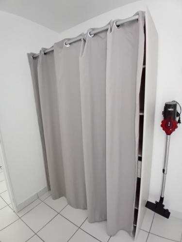 - une paire de rideaux blancs dans une chambre dans l'établissement Appartement cosy proche plage, à Saint-Nazaire