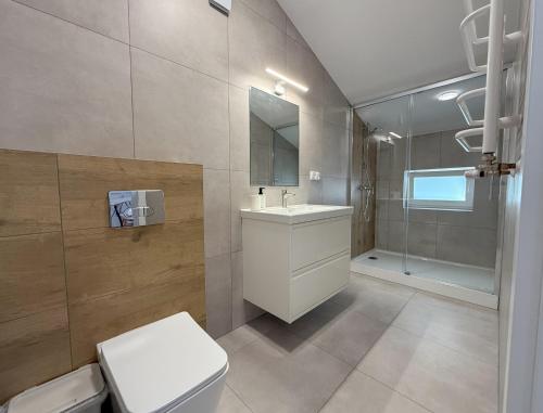 a bathroom with a toilet and a sink and a shower at Chatka Morska 3 Apartamenty in Karwia