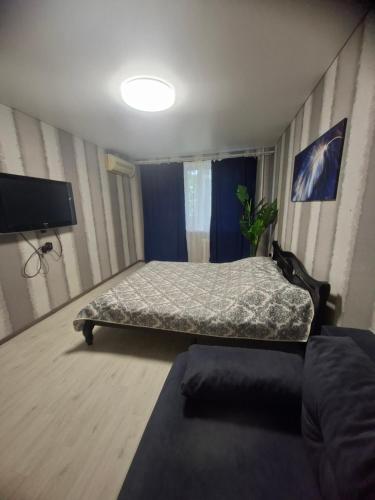 a bedroom with a bed and a flat screen tv at 2-х комнатная Квартира возле Солнечной галлереи in Yekaterinovka
