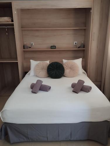 a large white bed with three pillows on it at Apartamento La Fuente 27 in Tomares