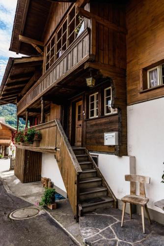 a wooden house with a staircase in front of it at Simple and Rustic - Apartment in Historic House in Wilderswil