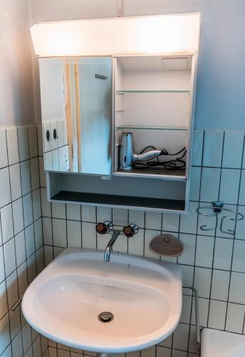 a bathroom with a sink and a medicine cabinet at Simple and Rustic - Apartment in Historic House in Wilderswil