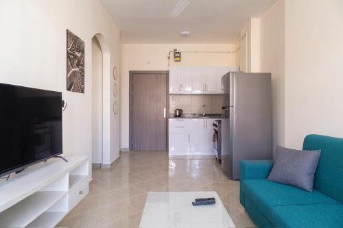 a living room with a blue couch and a kitchen at Bayt Hassan A11 - 2 bedrooms spacious appartment in Hurghada