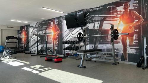 a gym with a wall mural of a man doing a barbell at Hotel Marvel All Inclusive - FULLY RENOVATED FREE Beach Access in Sunny Beach