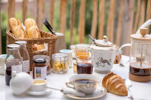 a table topped with a basket of bread and coffee at La Cabane du Domaine des Ecus d'Or in La Bussière-sur-Ouche