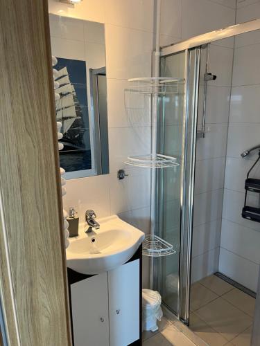 a bathroom with a sink and a shower at Apartamenty Kormoran in Sarbinowo