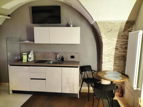 een keuken met een spoelbak en een tafel met stoelen bij Via Montecastello Emotional Room in Termoli