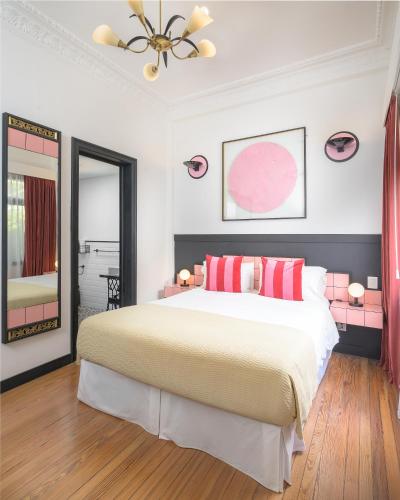 a bedroom with a large bed with red pillows at FAUNA Montevideo in Montevideo