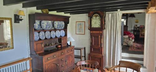 a room with a wooden dresser and a clock at Nature cottage in Snowdonia National Park in Beddgelert