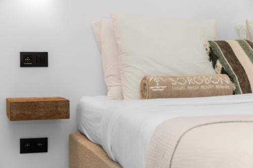 a bed with white sheets and pillows on it at Sorobon Bay Hotel in Kralendijk
