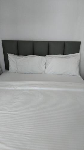a large white bed with white pillows on it at Baan der Bruyn SHA in Jomtien Beach