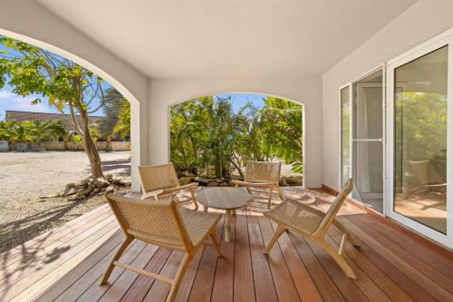 a room with a table and chairs on a wooden deck at Sorobon Bay Hotel in Kralendijk