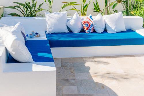 a blue and white bench with pillows on it at Via Farilya Hotel in Gundogan